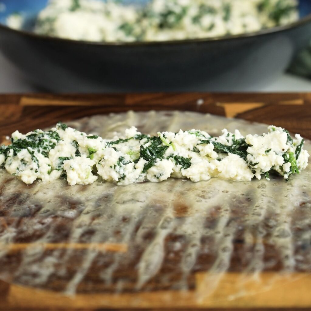 Feta and spinach filling placed on softened rice paper before rolling