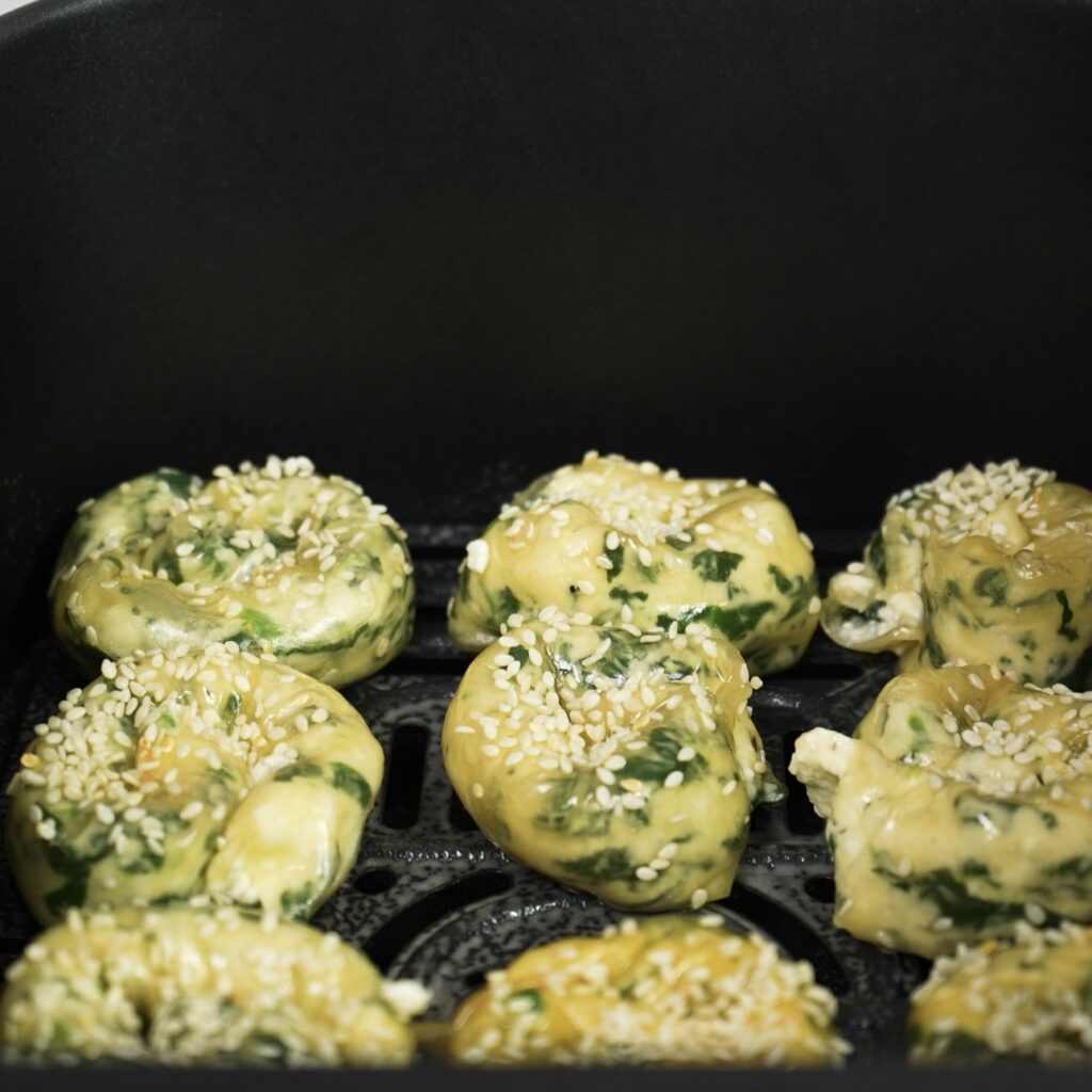 Rice paper rolls placed in an air fryer basket before cooking