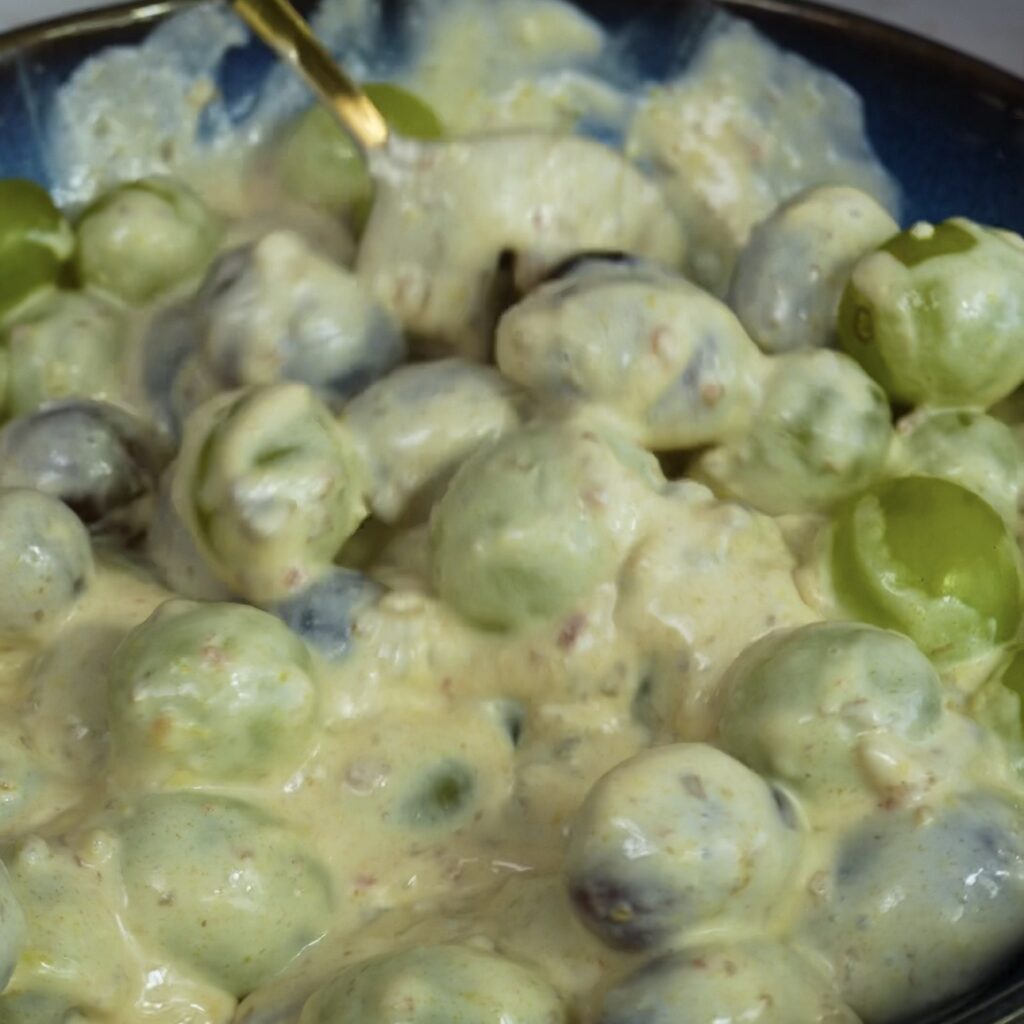Grapes mixed with yogurt in a bowl for frozen yogurt bars