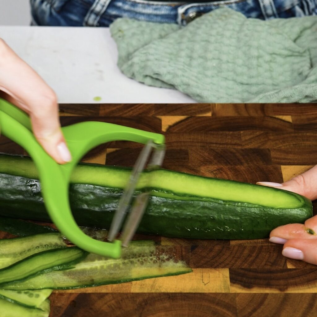 Slicing cucumber into thin ribbons with a vegetable peeler