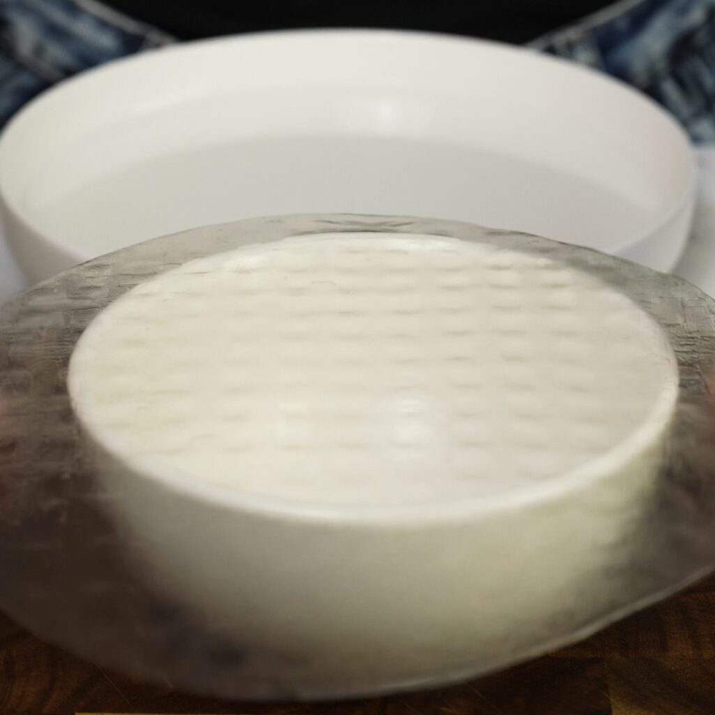 Rice paper sheet placed over a greased bowl to shape mango mochi