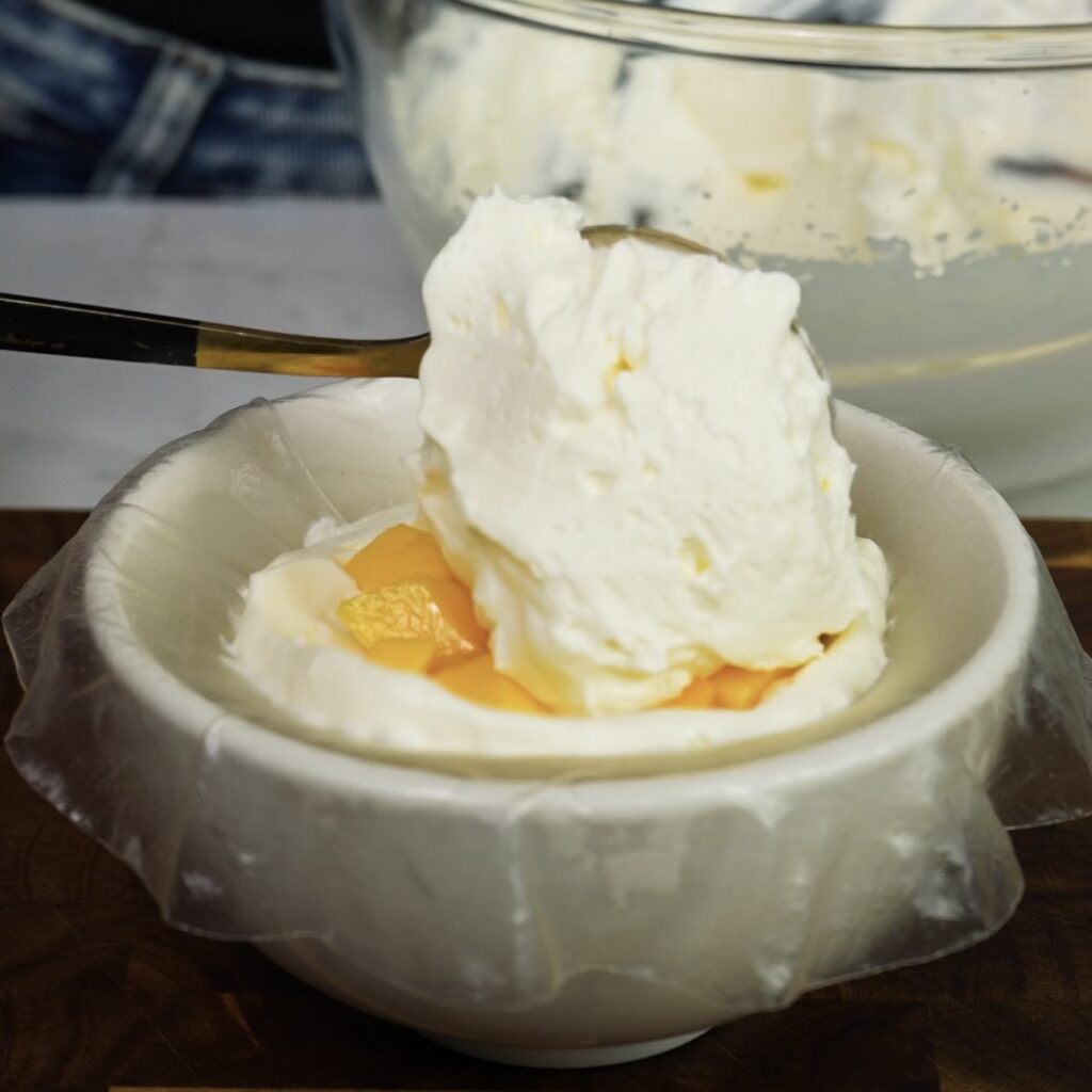 Final layer of cream added over mango filling on rice paper mochi
