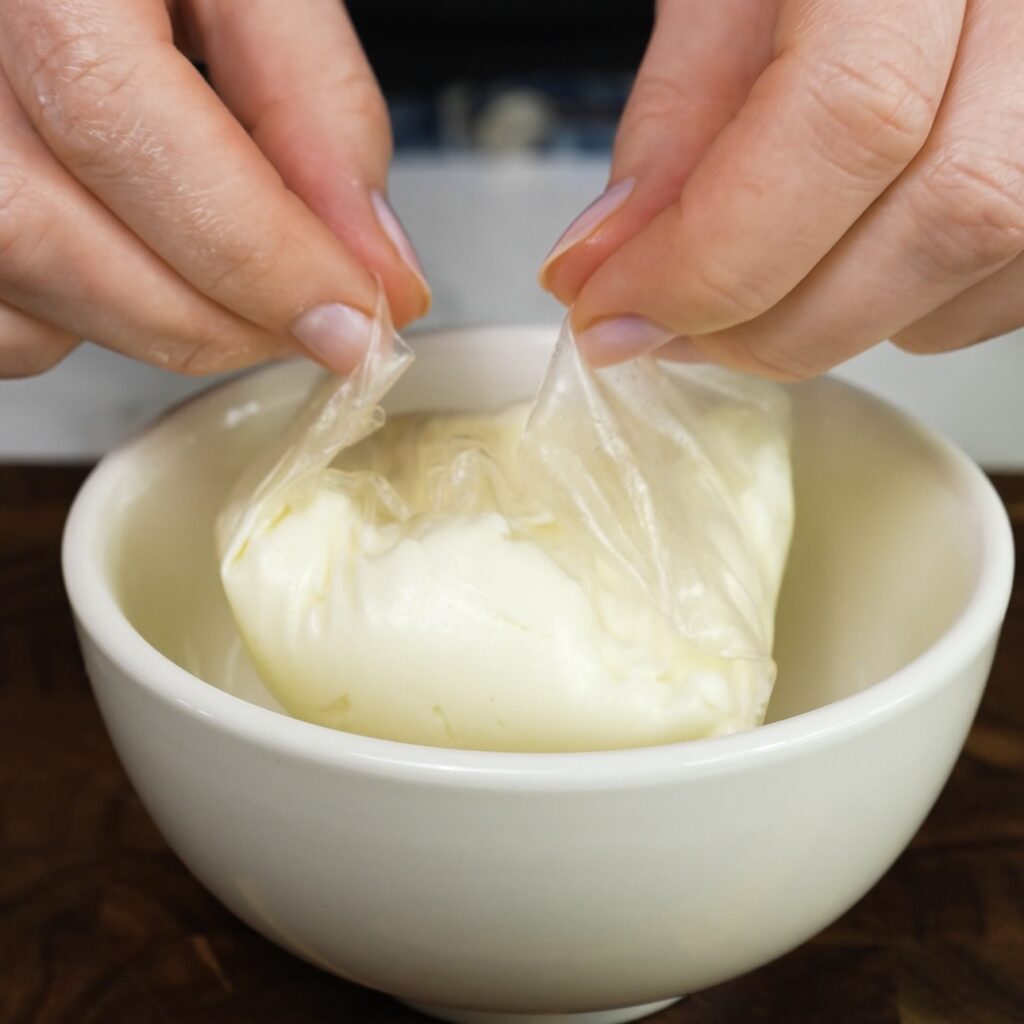 Edges of rice paper brought together to seal mango mochi