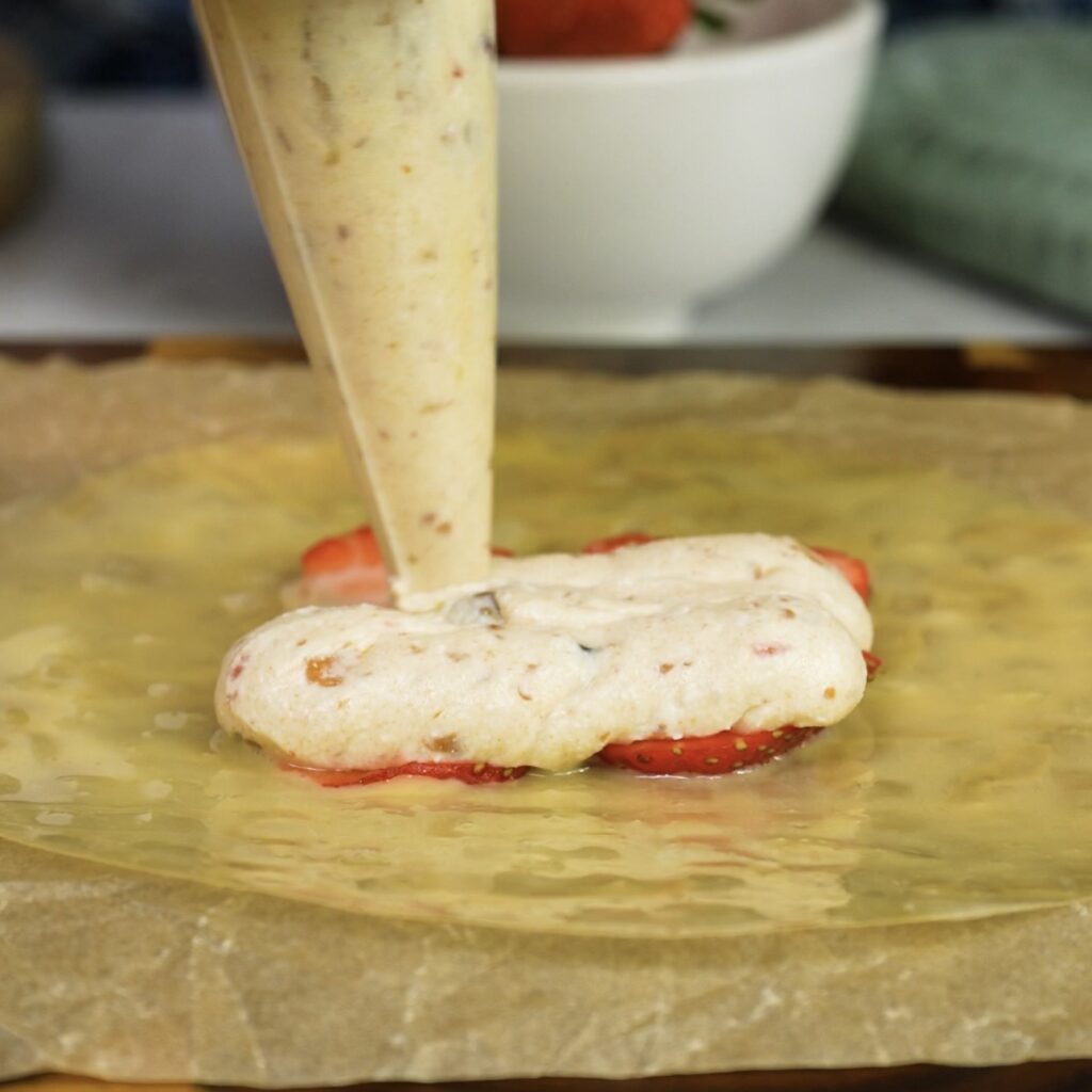 Cottage cheese filling piped over strawberries on rice paper