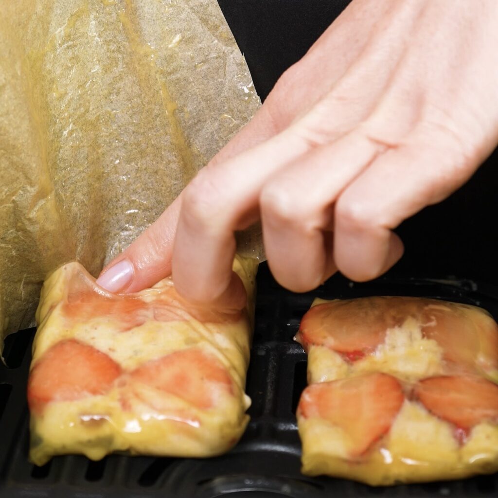 Rice paper parcels placed in air fryer basket with parchment removed