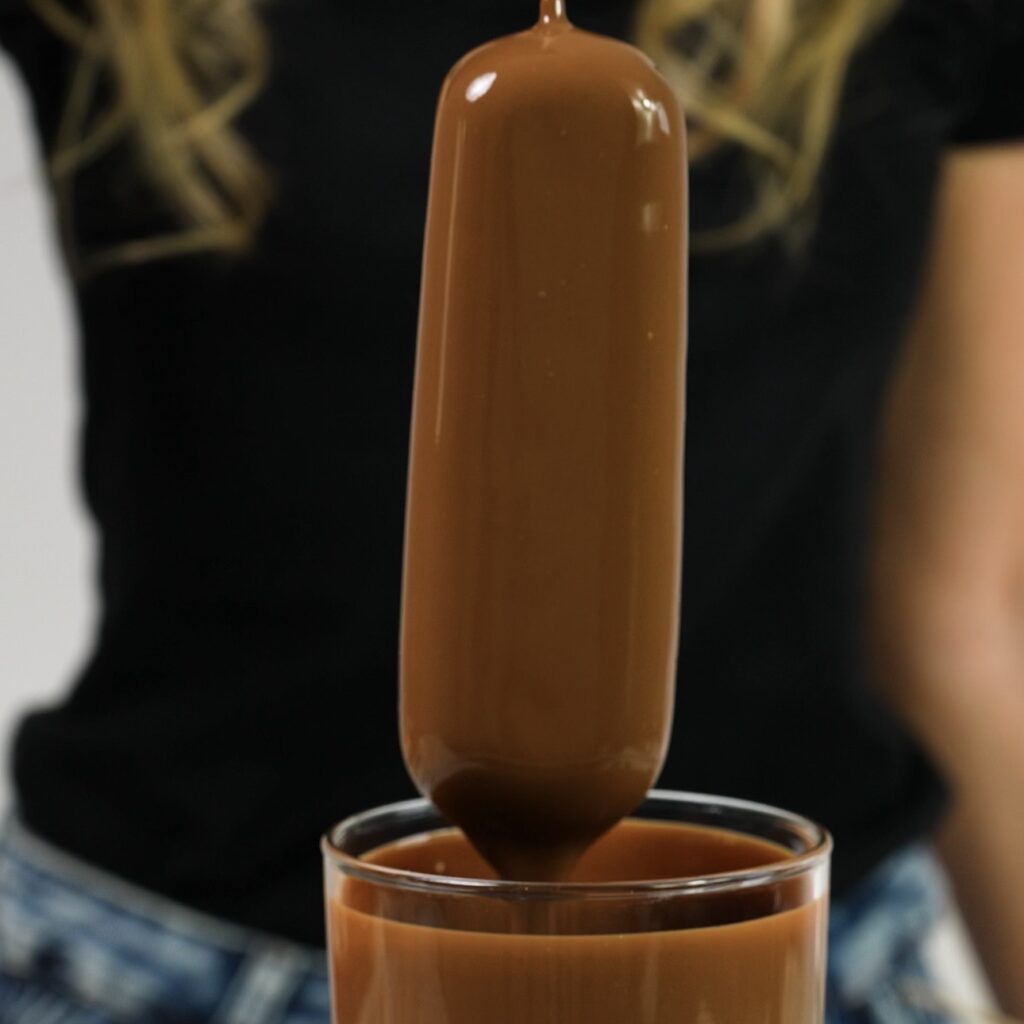 Protein bar dipped into smooth chocolate glaze for coating