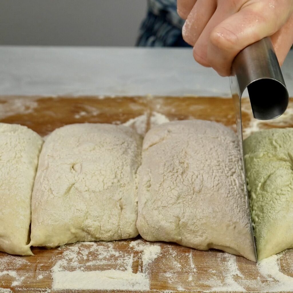 Dividing ciabatta dough into portions with a dough scraper