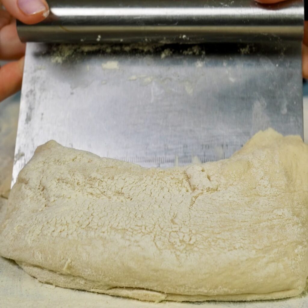 Placing ciabatta dough portion onto a floured kitchen towel