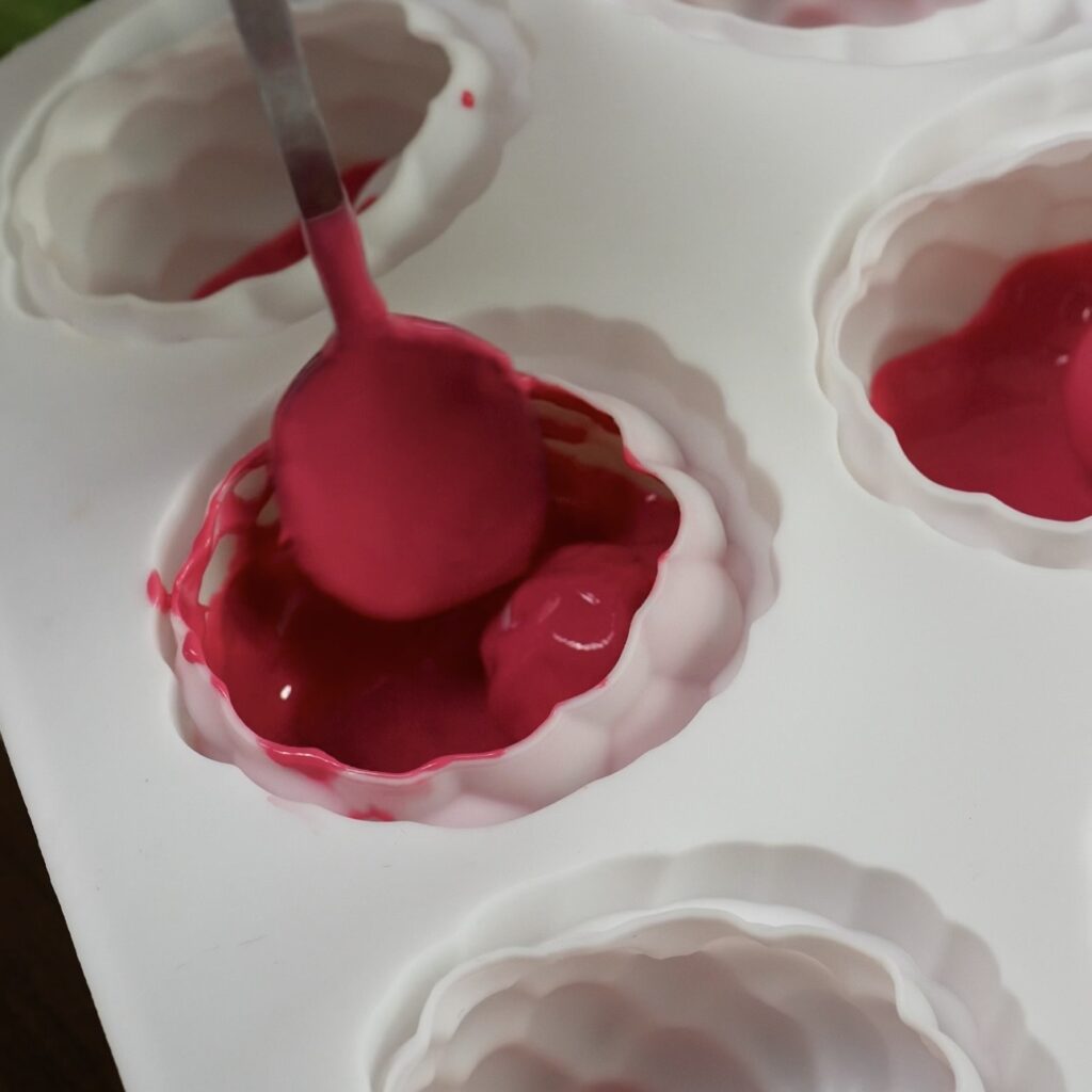 Filling raspberry silicone mould cavities with chocolate glaze