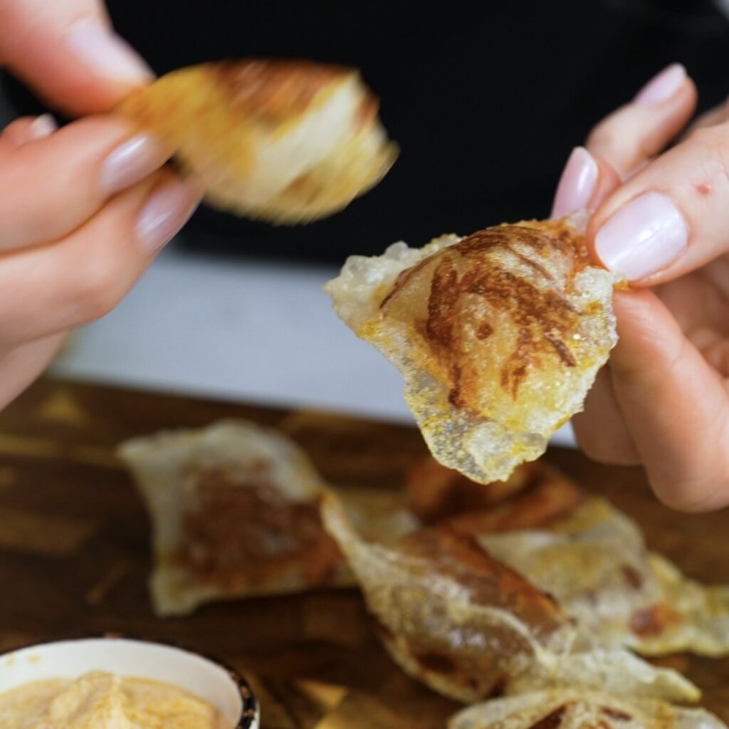 Hands holding crispy rice paper mozzarella chips