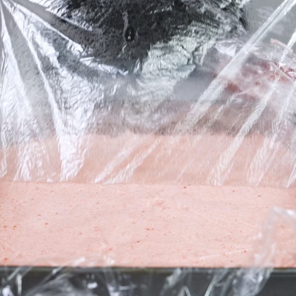 Removing cling film from set strawberry fluff squares