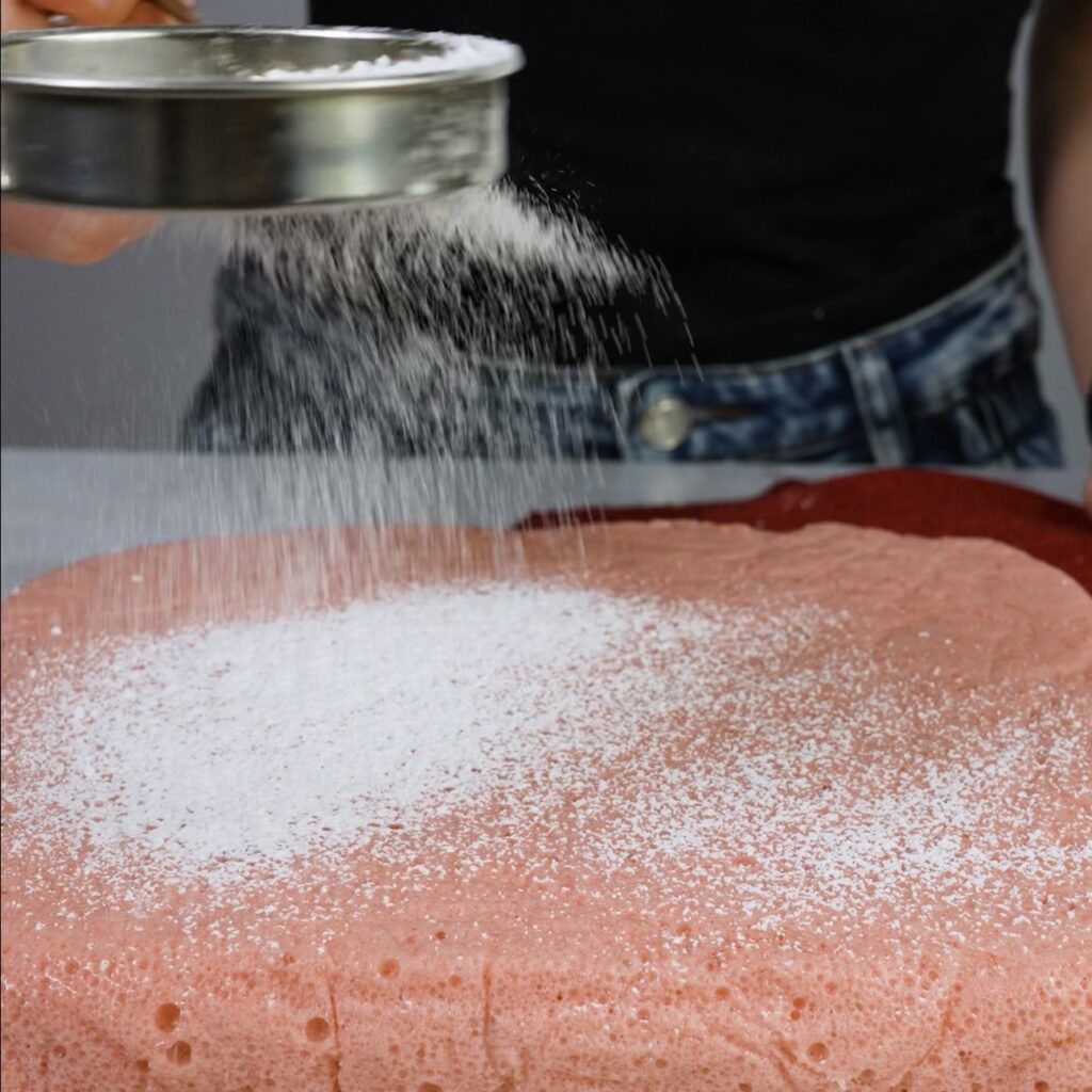 Dusting strawberry fluff squares with cornflour and icing sugar