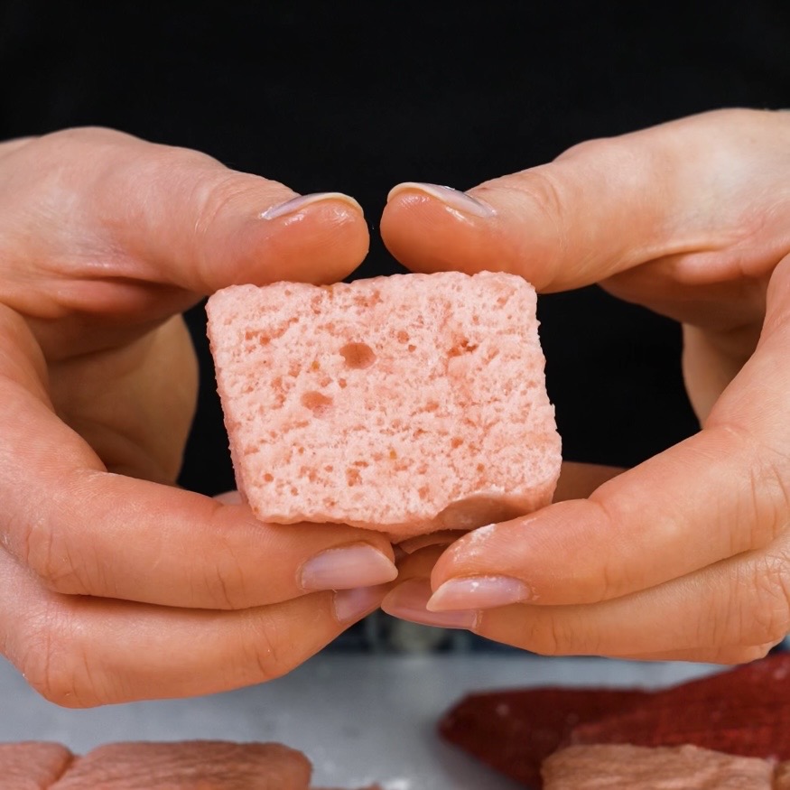 Hands holding a soft strawberry fluff square