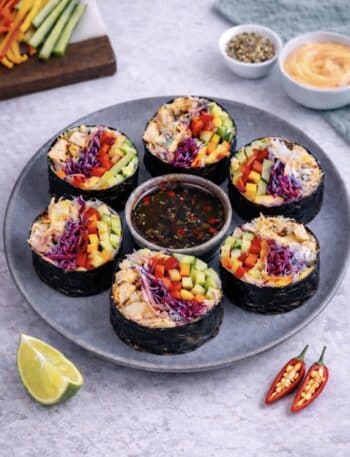 Sliced rice paper chicken nori rolls served on a plate with dipping sauce