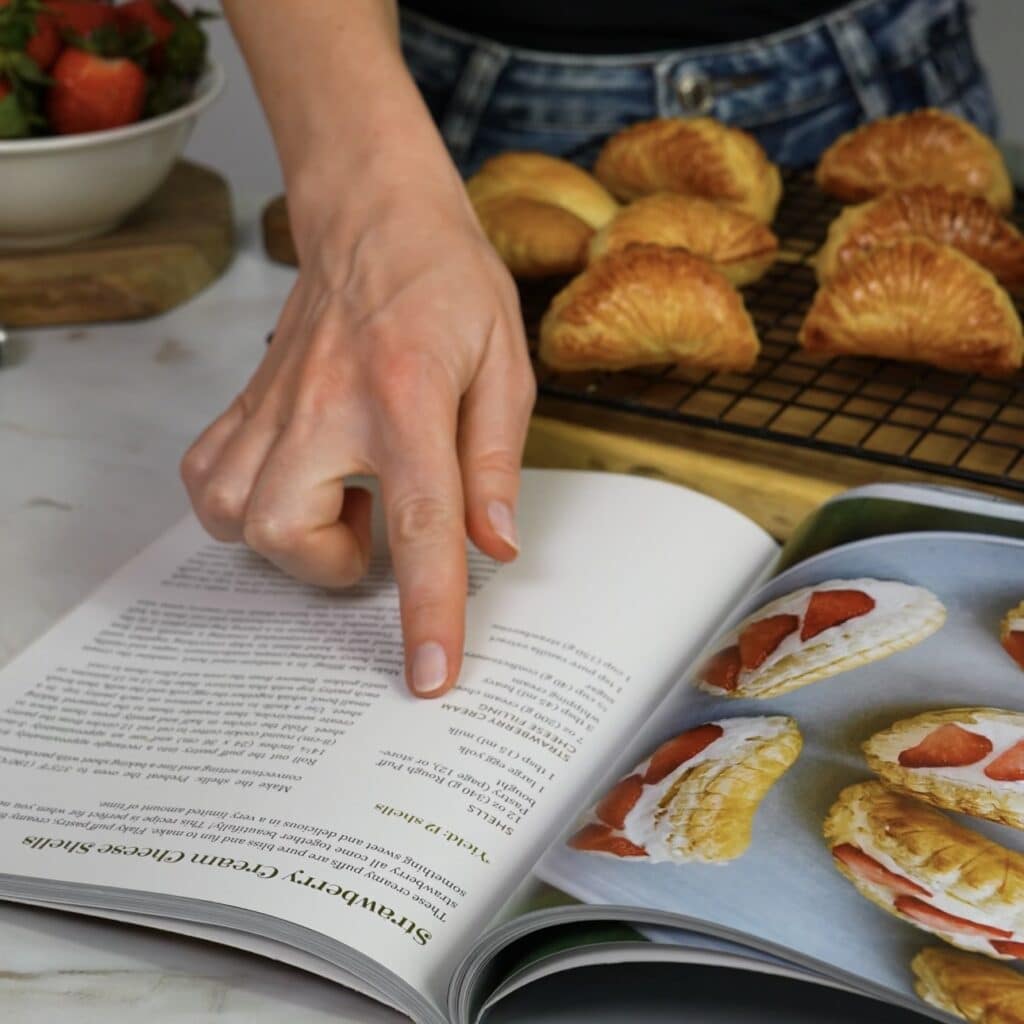 Open cookbook showing the strawberry cream cheese shells recipe