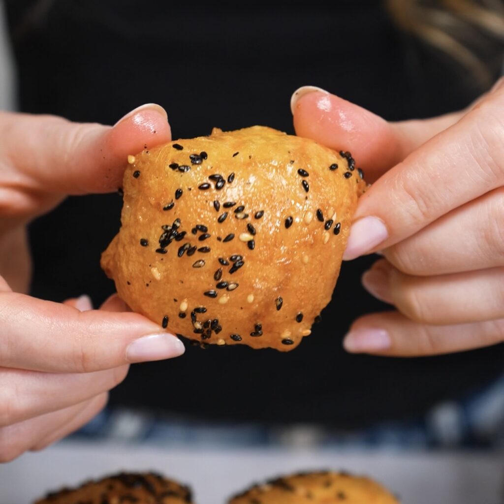 Hands holding crispy rice paper cheese ball