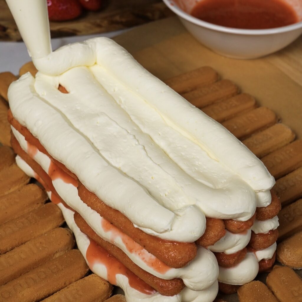 Spreading final layer of mascarpone cream on tiramisu