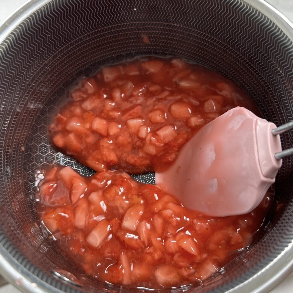 Cooking strawberry sauce in a saucepan
