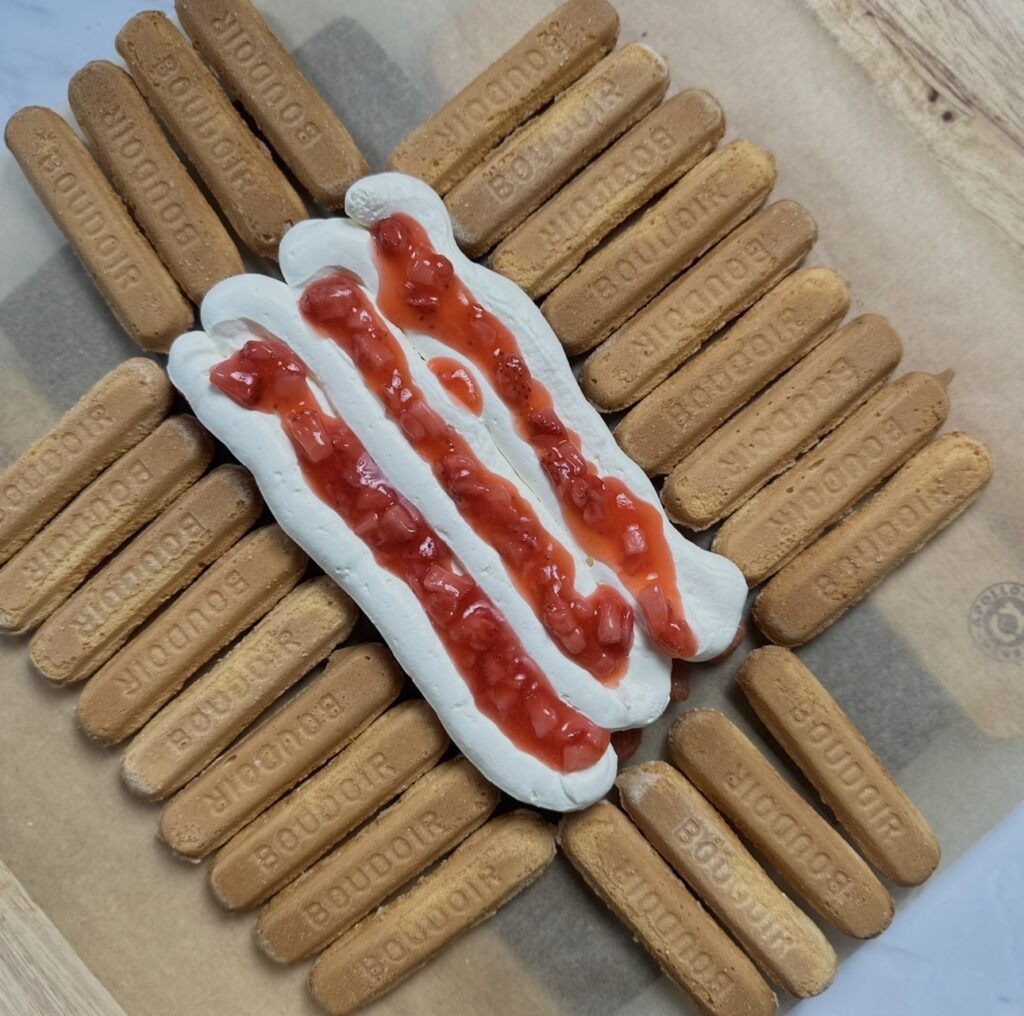 Adding first layer of mascarpone cream and strawberry sauce