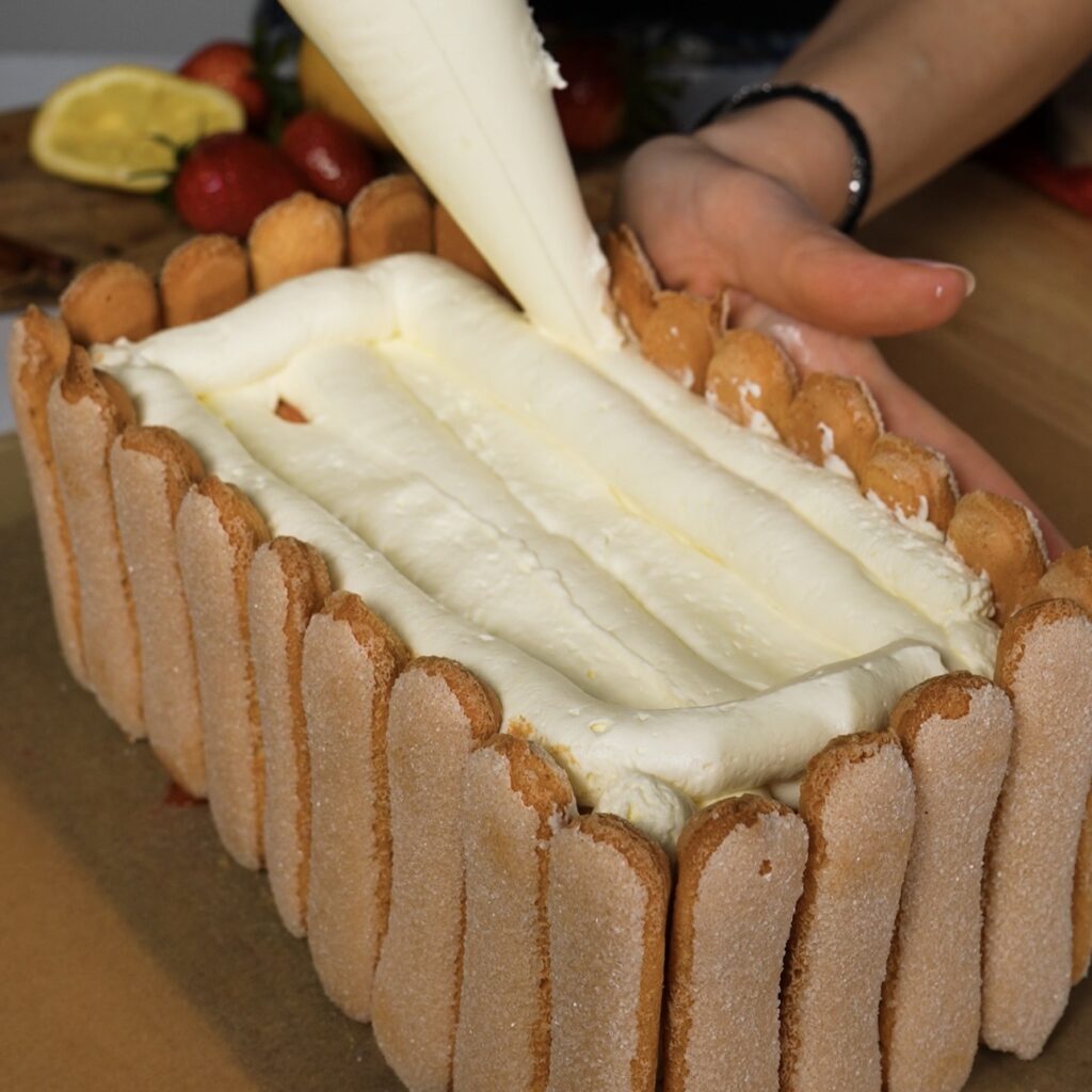 Building mascarpone cream border around tiramisu edges