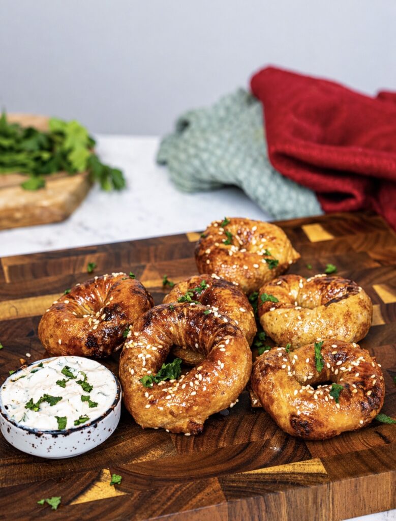 Air Fryer Pesto Parmesan Rice Paper Rings served on a wooden board with dipping sauce