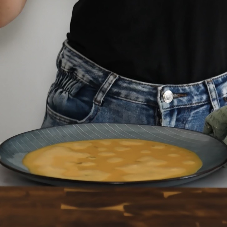 Eggs whisked with milk in a shallow plate, ready for dipping rice paper