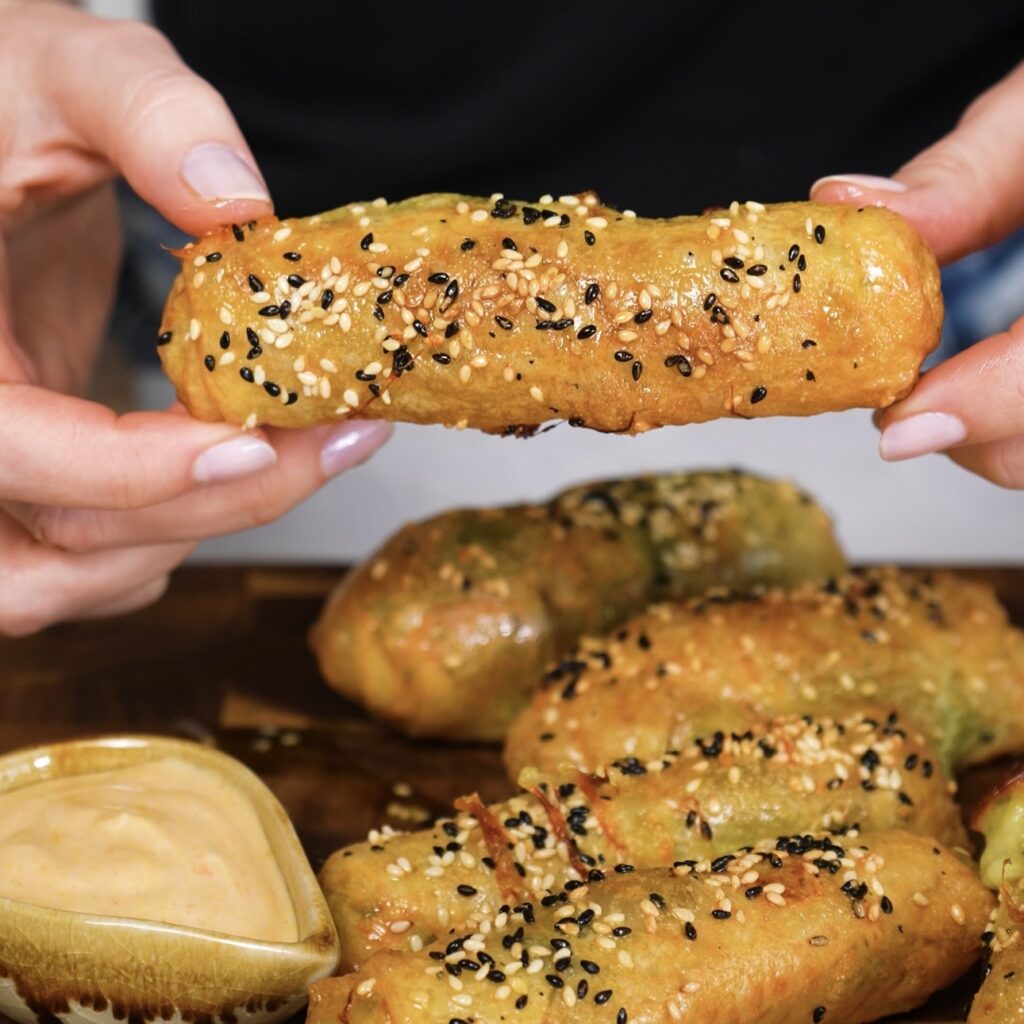 Hands holding a warm air-fried rice paper mozzarella stick