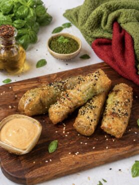 Air Fryer Pesto Mozzarella Rice Paper Sticks served on a wooden board