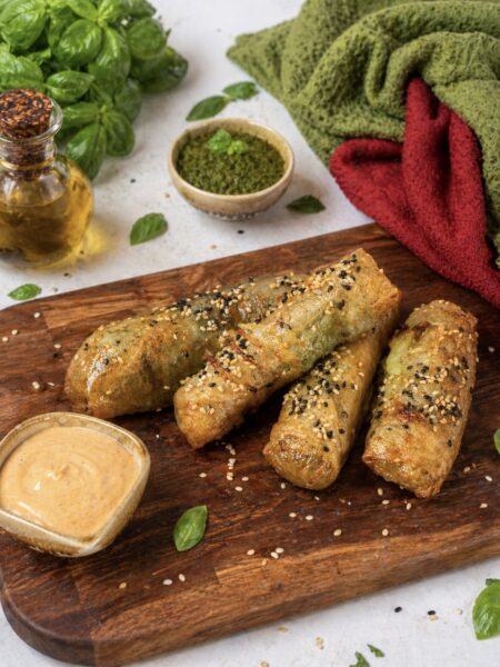 Air Fryer Pesto Mozzarella Rice Paper Sticks served on a wooden board