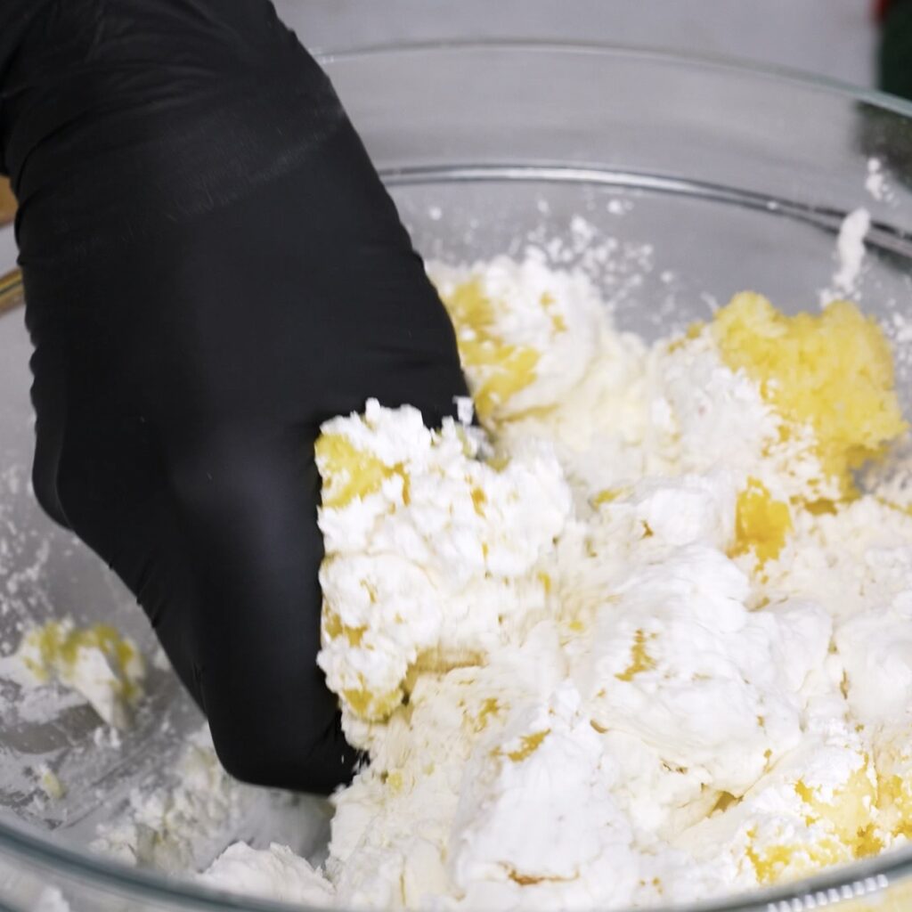 Mixing smooth potato dough with cornflour in a bowl