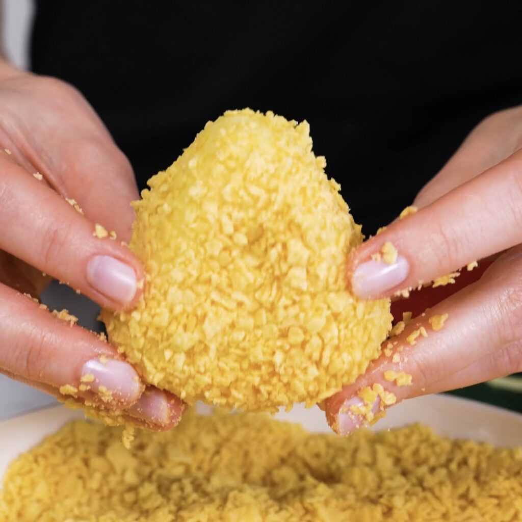 Potato triangle coated in crushed potato chips ready for air frying