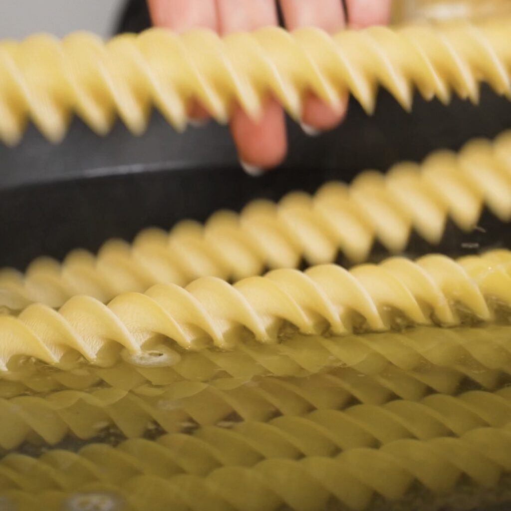 Adding pasta to a pot of boiling salted water