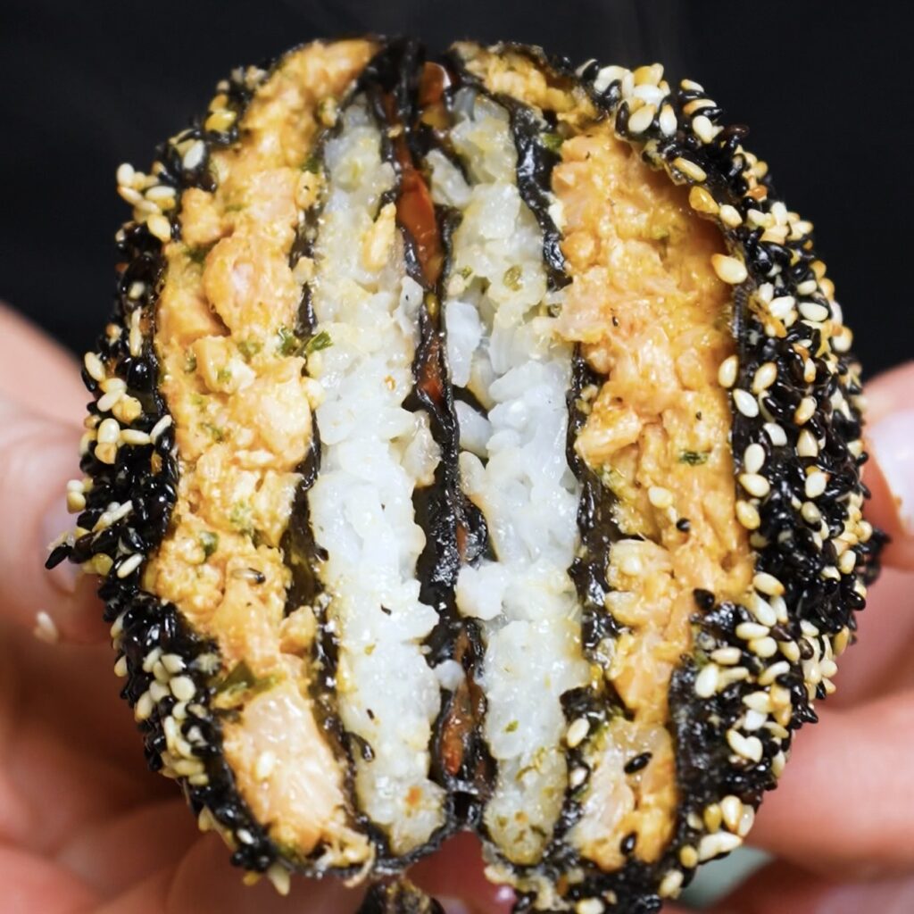Air Fryer Salmon Sushi Parcel sliced in half to reveal the salmon, rice, and tomato filling