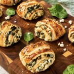 Spinach and feta puff pastry rolls served on a wooden board
