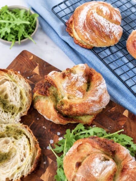 Freshly baked No-Knead Pesto Mozzarella Bread Twists served on a wooden board.