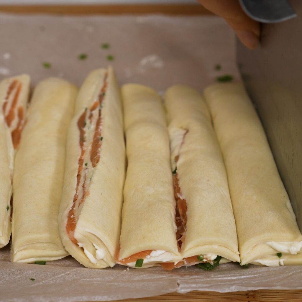 Layered puff pastry cut into eight to nine strips.