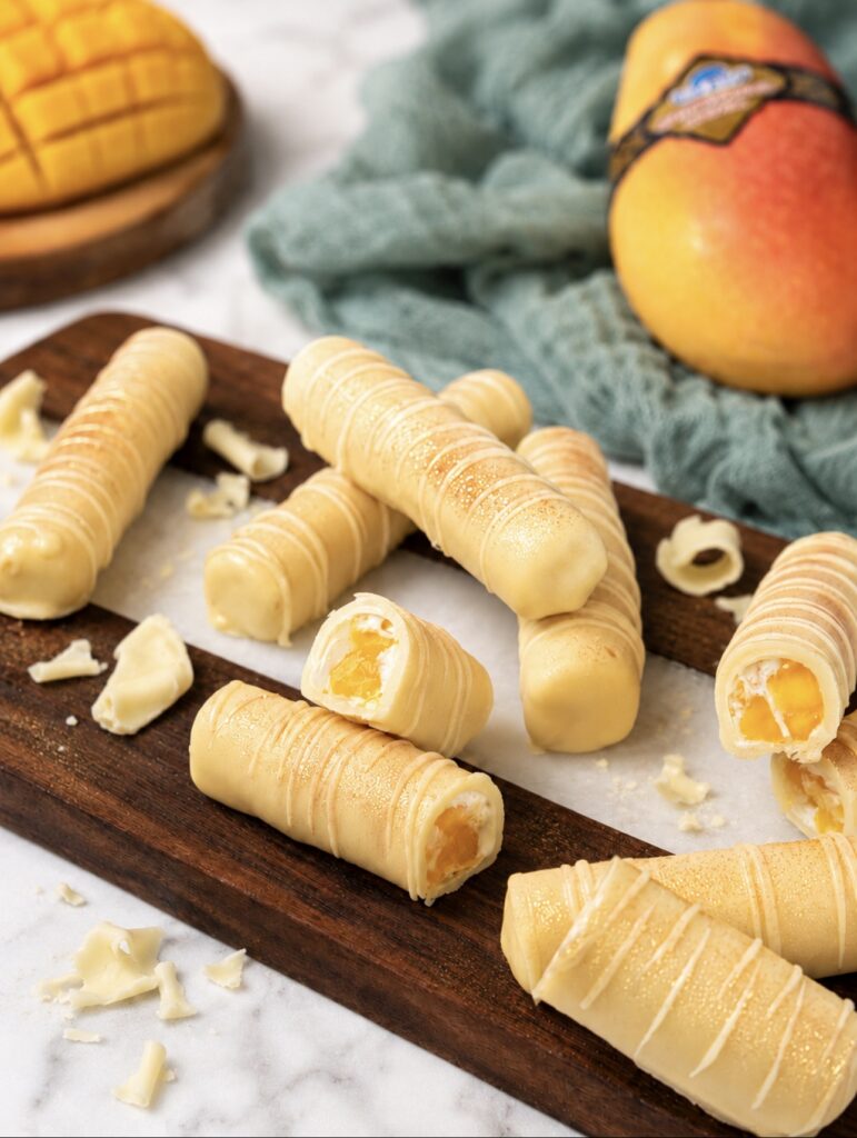 Frozen mango yogurt bars served on a wooden board.