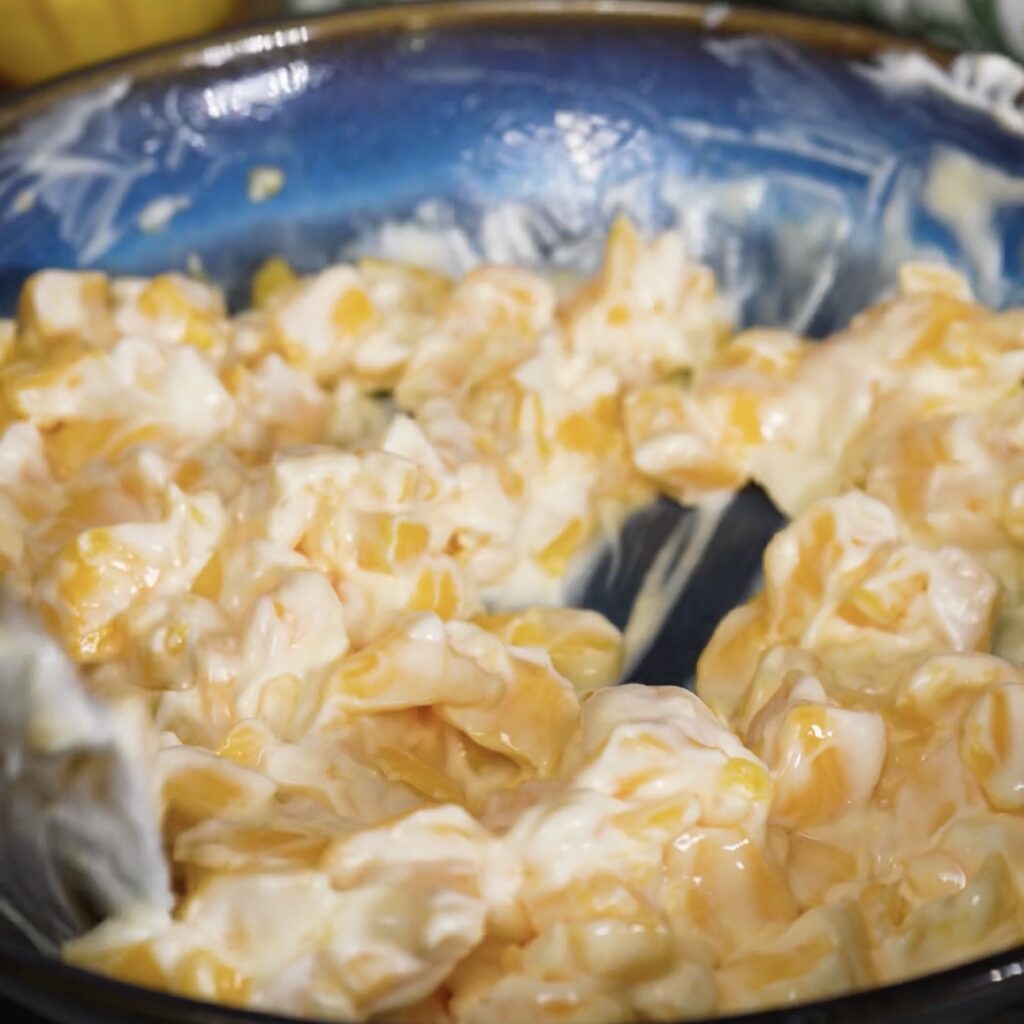 Diced mango mixed with thick yogurt in a bowl.