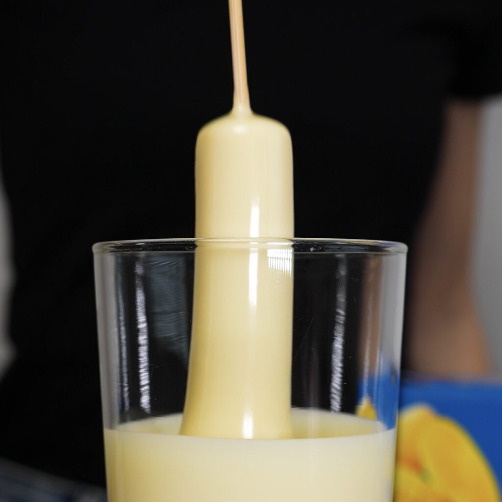 Dip the frozen mango yogurt bar into melted chocolate.