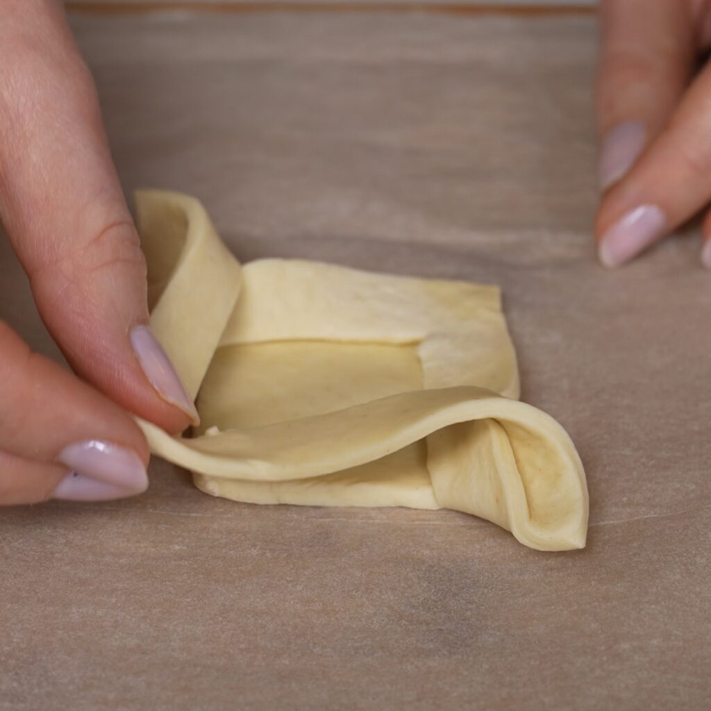 Second loose puff pastry corner folded over to create an open pastry shape.
