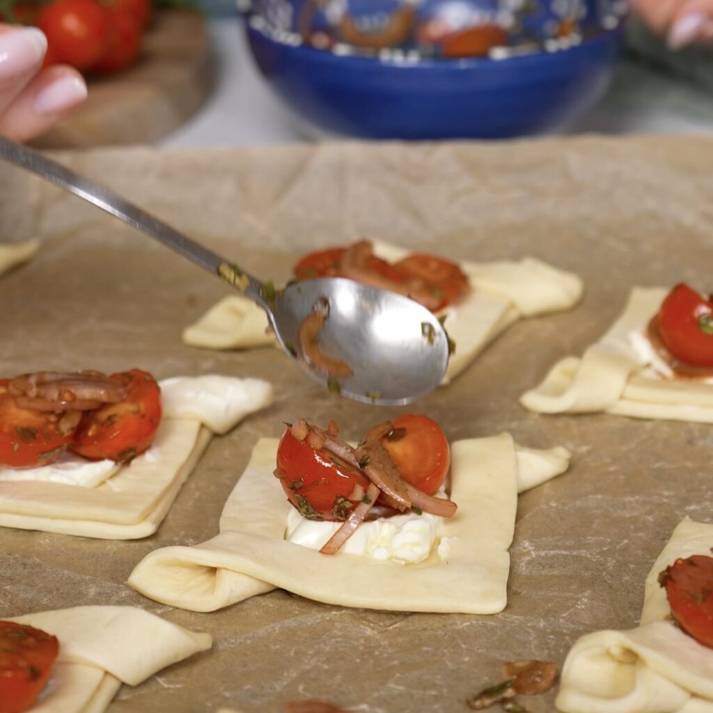 Shaped puff pastry topped with cream cheese, cherry tomatoes and shallots.