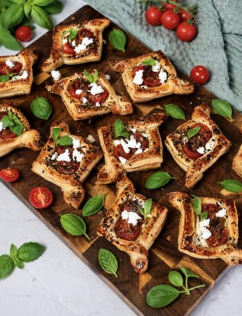 Balsamic tomato and feta puffs served on a wooden board.