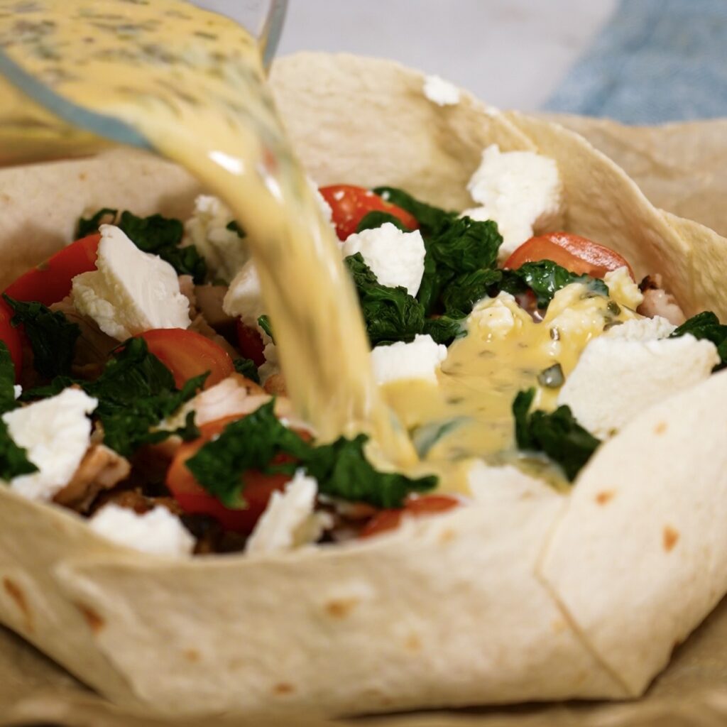 Pouring the egg mixture into the filled tortilla crust.