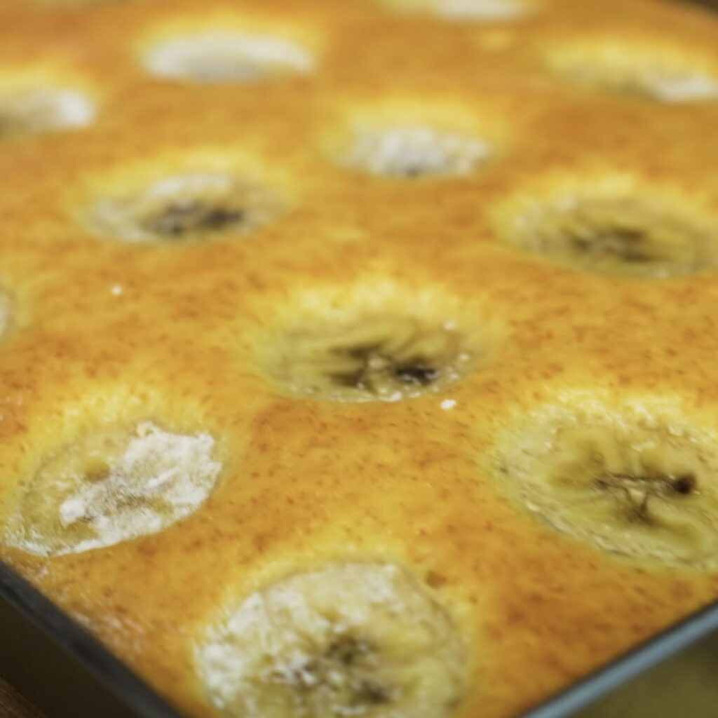 Baked cake in a parchment-lined tray.