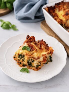 Piece of baked spinach and ricotta lasagna served on a plate
