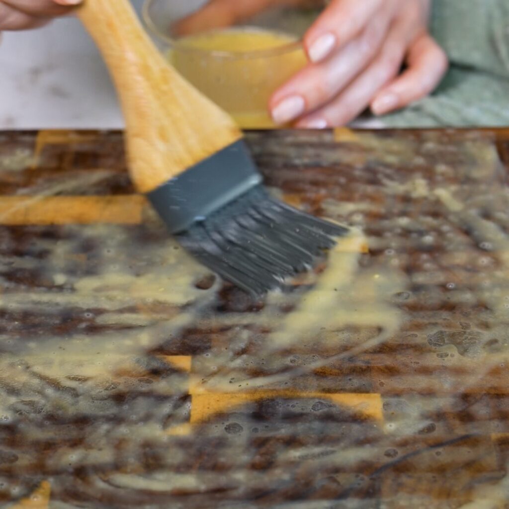 Brushing rice paper with egg mixture for air fryer salmon en croûte.