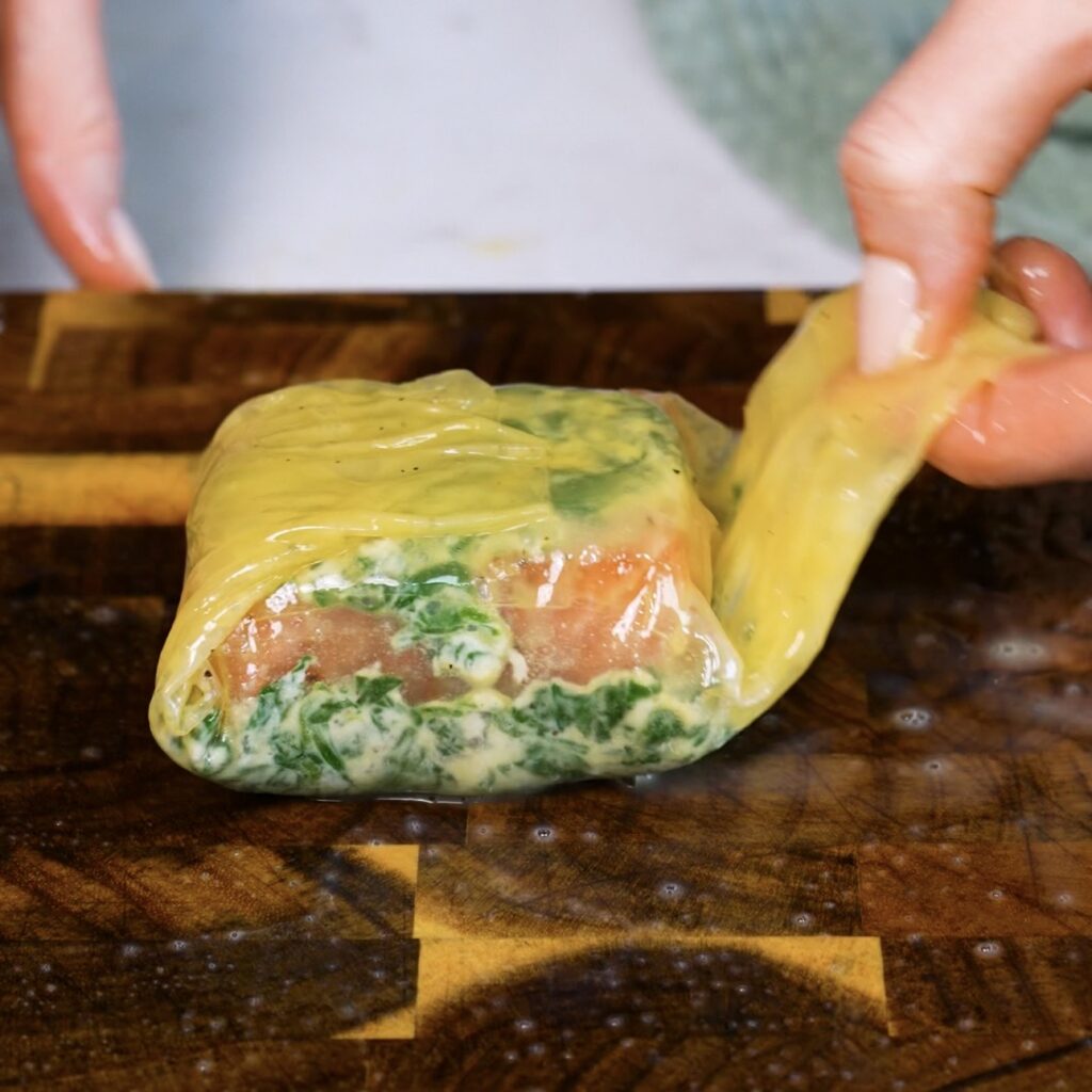 Folding rice paper over the salmon to form a parcel.