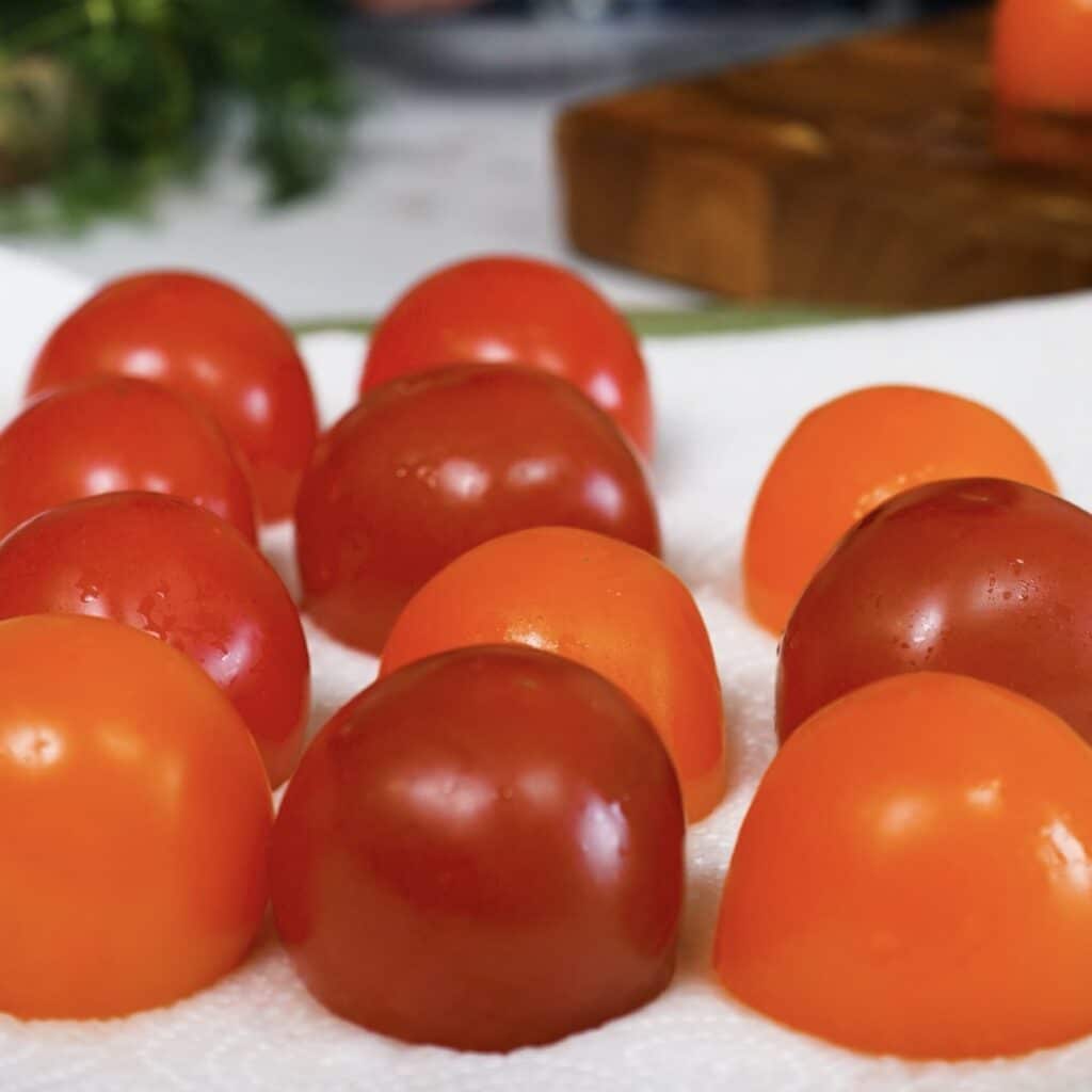 Hollowed cocktail tomatoes placed cut-side down on a paper towel