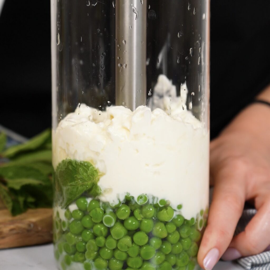 Pea, mint and cottage cheese sauce being blended until smooth.
