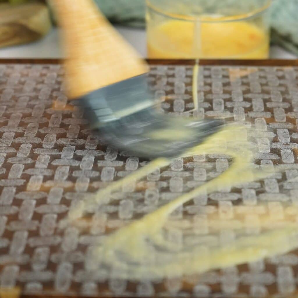 Brushing rice paper with egg wash for rice paper cheeseburger rolls